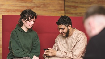 two students looking at phone