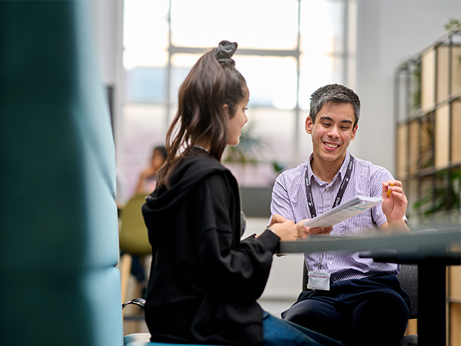 Student being tutored by a supportive member of staff.